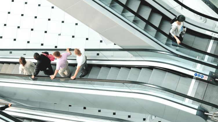 shoppers on an escalator