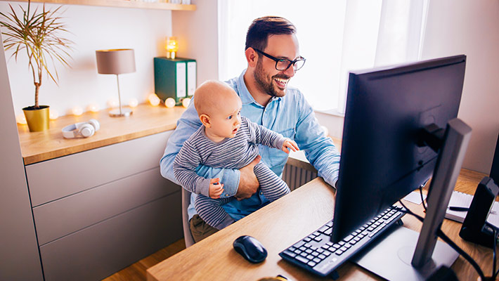 Employee working from home while carrying his child