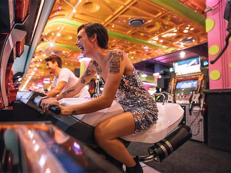 Couple playing an arcade racing game sitting on bikes