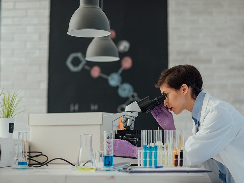 Female lab assistant working in laboratory and doing research on the samples