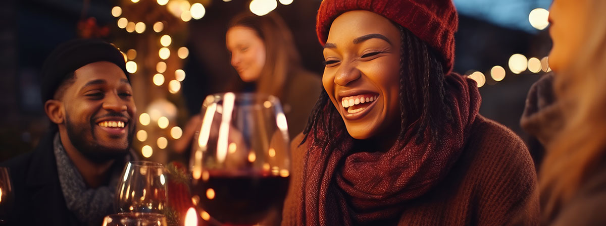 Youthful individuals socializing drinking and eating nourishment sitting exterior at vineyard bar table Winter season