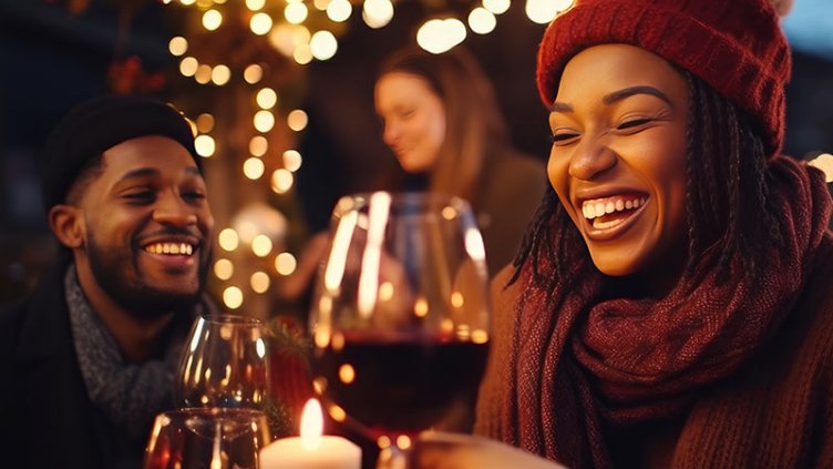 Youthful individuals socializing drinking and eating nourishment sitting exterior at vineyard bar table Winter season