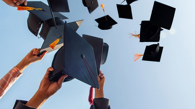 College graduates toss their caps in celebration