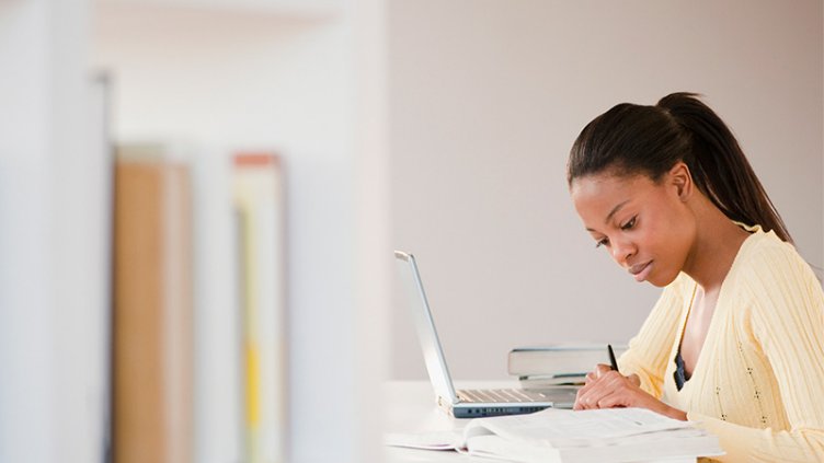 Mixed race woman doing homework with laptop