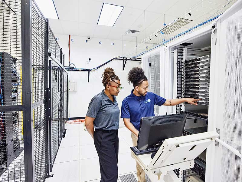 IT professionals in discussion while configuring server in data center
