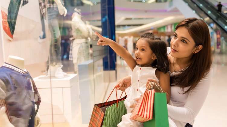 Little girl showing something in the showcase to her mother