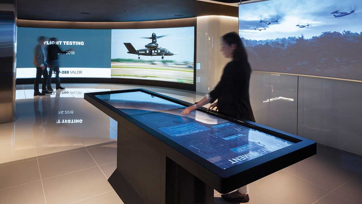 Picture of a woman using interactive touchscreen display in JLL office