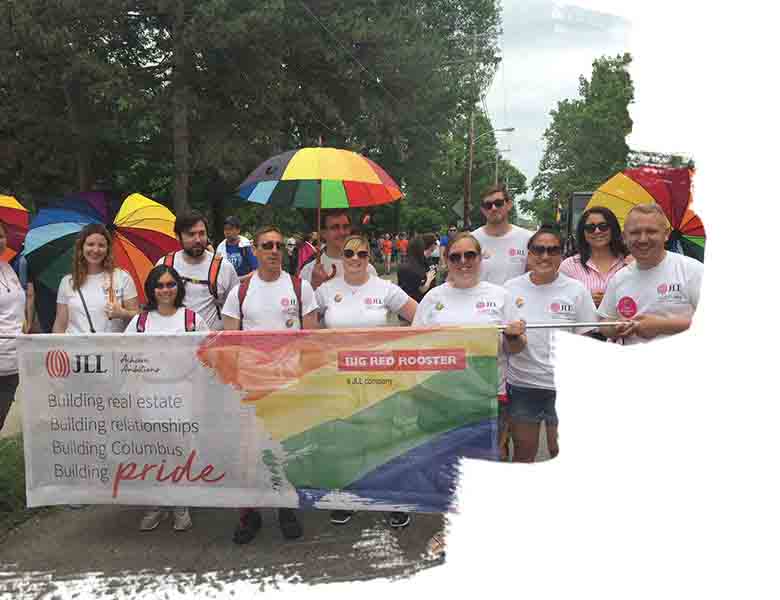 Group picture of JLL employees in a local event holding a banner