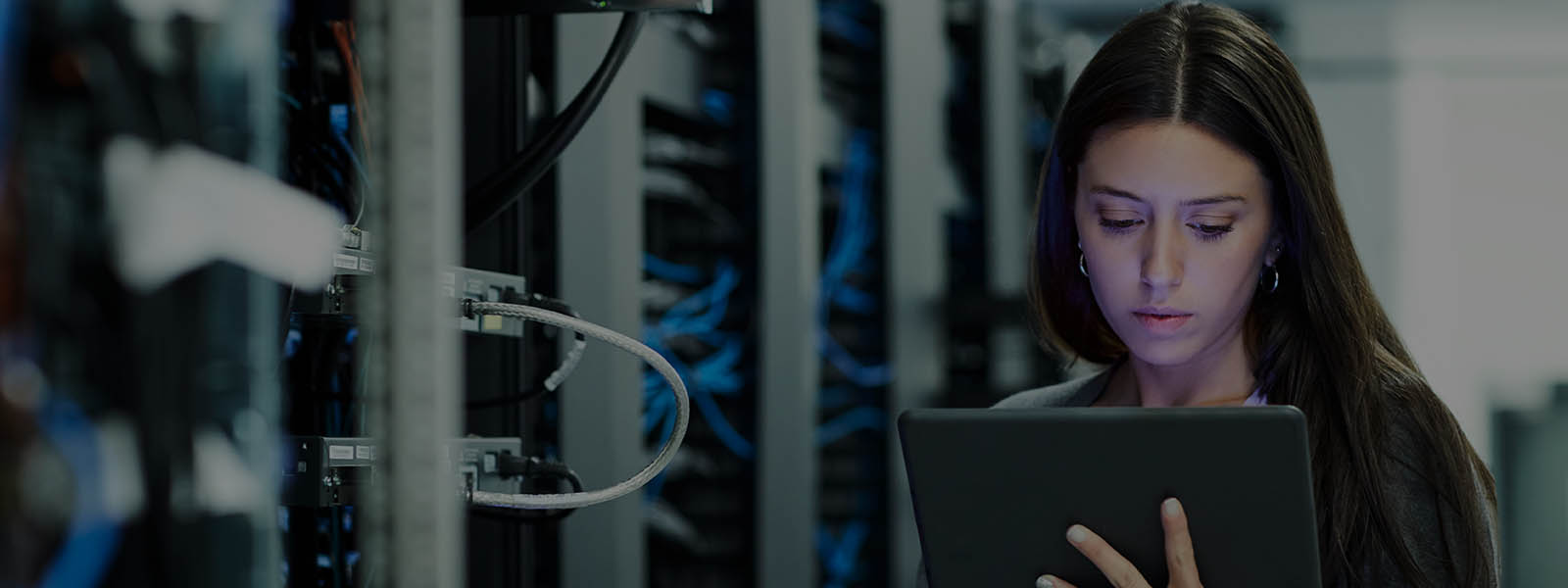 Data center administrator checking the network connections on tablet at data server room