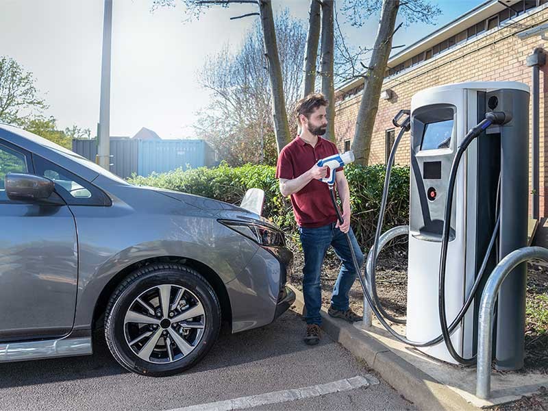 Man preparing to charge an electric car at an EV charging station