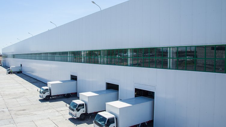 delivery trucks backed into shipping and receiving bays at warehouse