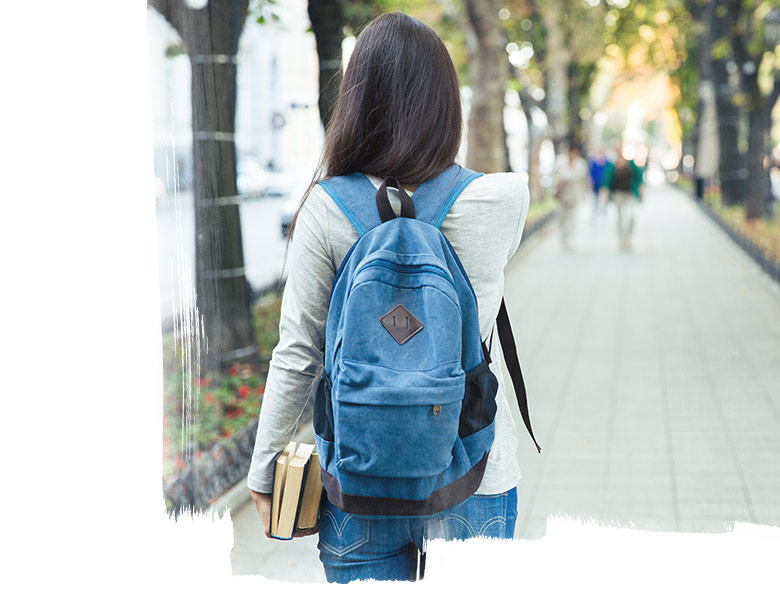Girl walking along the street with blue bagpack