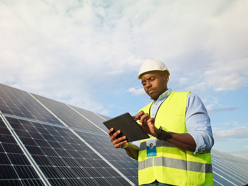Engineer check the maintenance of solar panels by using digital tablet