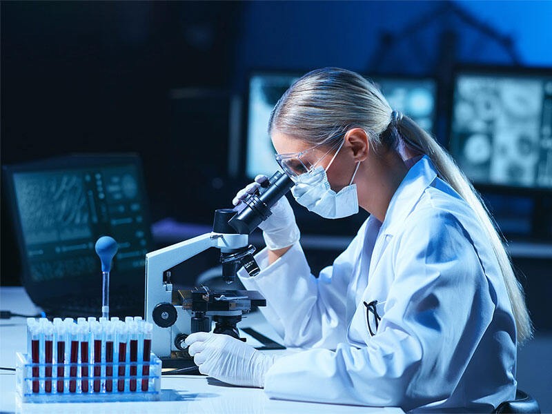 Female scientist analyzing the diagnostics through equipments in modern laboratory