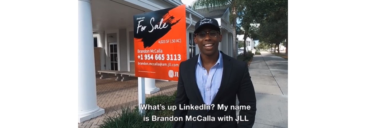 Brandon McCalla in front of a for sale sign with his name on it.