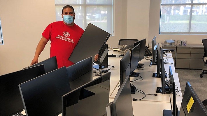 IT technician installing monitor screen in JLL office workplace