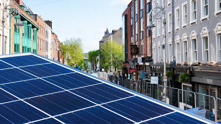 Close up of solar panels with the city of Dublin, Ireland in the background.