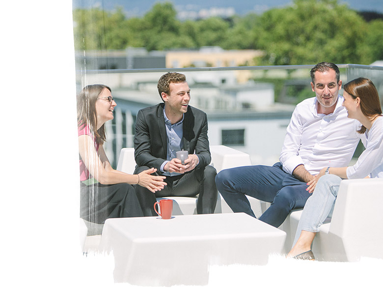 Four people having a conversation on an office roof deck